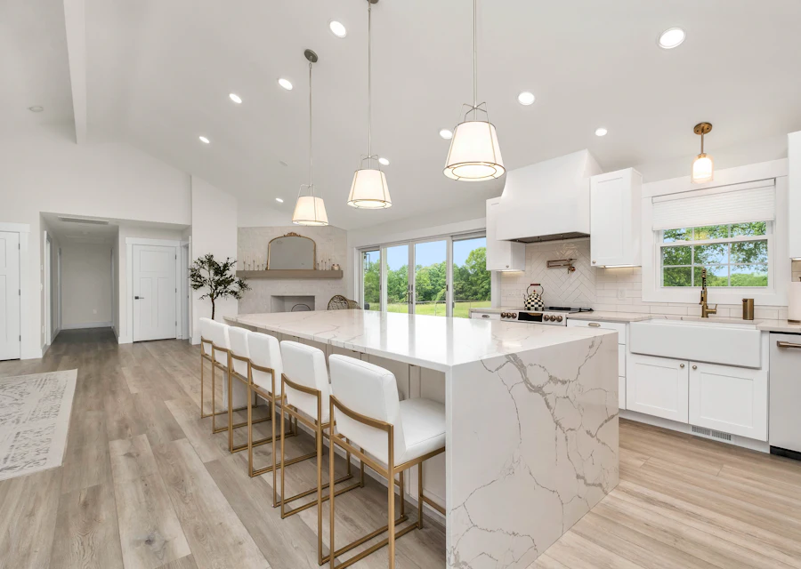 A large white kitchen with a long island