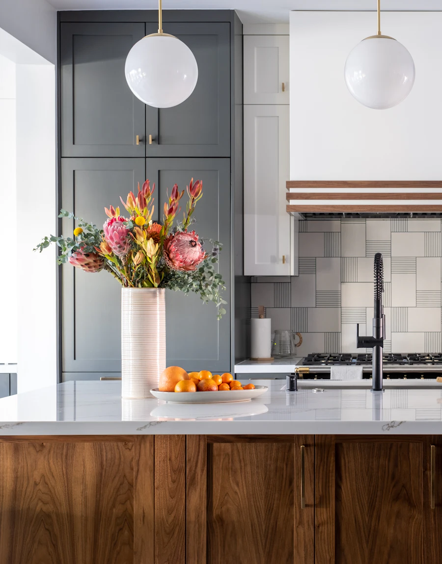 A kitchen with marble counters and wood cabinets